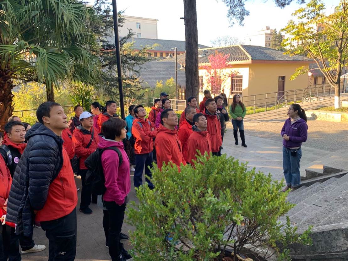 A group of people walking on a sidewalk Description automatically generated